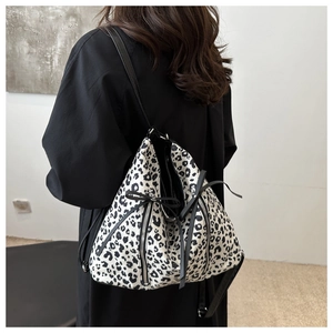 Vista detallada del bolso tote con estampado de leopardo y cremalleras dobles decorativas