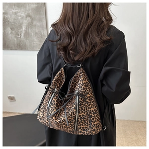 Dettaglio della borsa tote in tela leopardata con zip argentate e laccetti in pelle