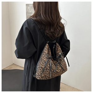 Vista trasera detallada de un bolso tote con estampado de leopardo y lazo negro de cinta