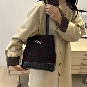 Women's black shoulder tote bag with red heart pattern and silver bow on trench coat