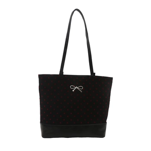 Black heart-print tote bag with leather trim and a silver bow detail on white background