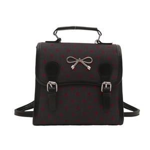 Gray canvas backpack with red heart prints and silver metal bow on white background