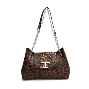Large leopard print shoulder bag with metal T-clasp and chain straps on white background