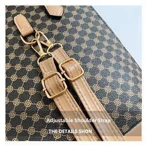 Detail view of the adjustable brown faux leather shoulder strap with gold metal buckles