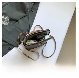 Macro view of inner capacity showing phone and fan in brown litchi pattern bag