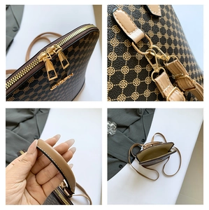 Detail shot of the golden zipper, hardware buckle and logo on brown shell bag