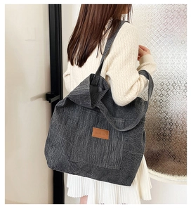 Detail of grey denim tote bag with leather patch on female shoulder for daily commuting