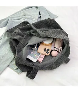 Detail showing high-capacity interior of dark grey canvas tote bag with textured denim fabric