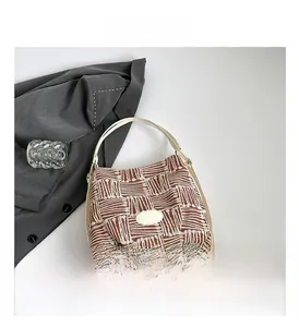 Détail du sac cabas tissé avec motifs géométriques, bandoulière en cuir et boucle argentée