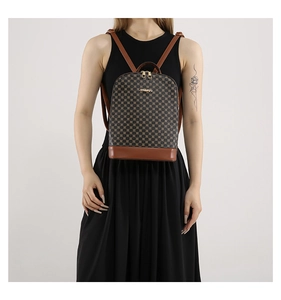 Detail showing vintage checkered backpack with brown leather handles and golden hardware