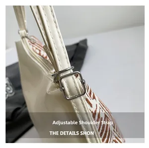 Détail de la boucle en métal argenté réglable sur le sac en cuir crème et tissu à motifs