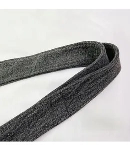 Close-up of thick canvas strap with reinforced stitching on a grey crossbody bag