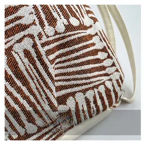 Détail macro du tissu jacquard haute densité avec motifs géométriques orange