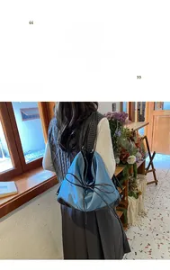 Blue denim tote bag detail featuring black leather trim and decorative bow accent