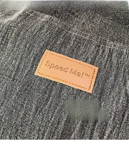 Close-up of the embossed brown leather logo on high-quality washed denim fabric texture
