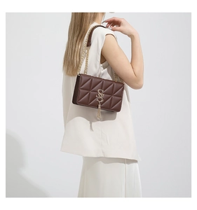 Detail view of brown quilted faux leather shoulder bag with gold chain and SS logo