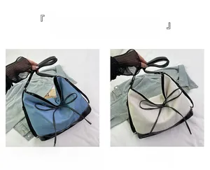 Detail of blue denim and beige canvas tote bags with bow ties and black leather trim