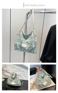 Detail view of green and white patterned bucket bag with white shoulder straps and patch