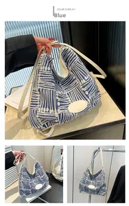 Detail view of woven shoulder bag with blue geometric patterns and white leather patch