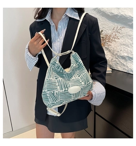 Détail d'un sac cabas tissé avec rayures géométriques vert et blanc et fines anses