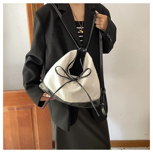 Detailed close-up of the two-tone tote bag with black bow detail and woven fabric texture