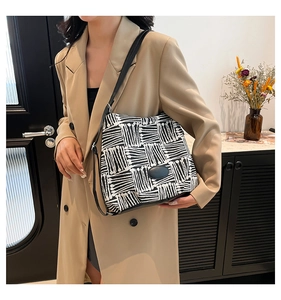 Détail du motif artistique noir et blanc sur la bandoulière d'un sac cabas minimaliste chic