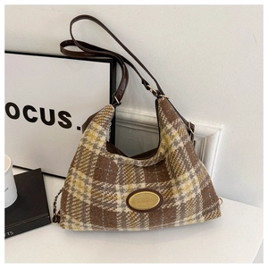 Detail of vintage plaid tweed hobo bag with gold logo plate and leather strap