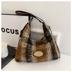 Close-up of brown plaid plush tote bag featuring soft faux fur texture and leather strap