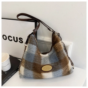 Detailed view of plaid plush tote bag with gold chain and leather shoulder strap