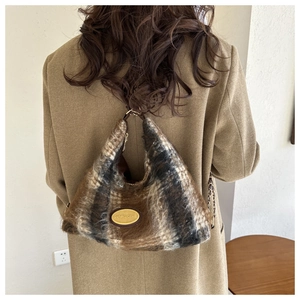 Detailed view of plush brown checkered shoulder bag worn by model in a minimal setting