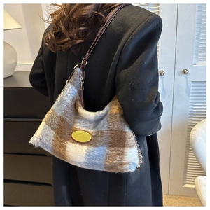 Close-up of blue and brown plaid plush shoulder bag with elegant leather chain strap