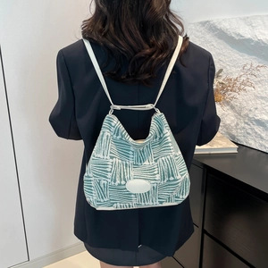 Minimalist geometric woven tote bag with white leather straps shown on a model