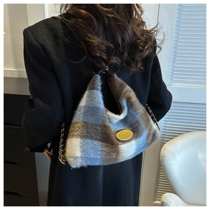 Detailed view of the plaid plush tote bag texture with elegant gold logo and chain strap