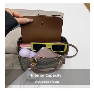 Macro view of the spacious inner compartment and brown monogram print of the shoulder bag