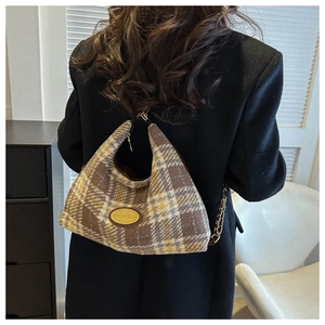 Detail of the vintage plaid hobo bag featuring tweed fabric and metal chain strap