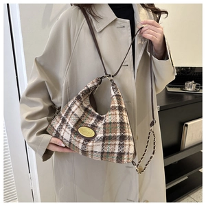 Elegant plaid tweed crescent shoulder bag with leather trim and gold chain strap on model