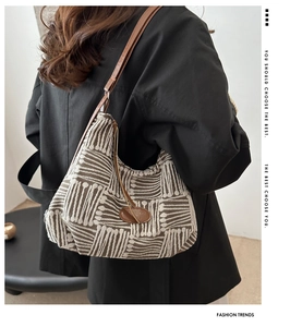 Detail of hobo shoulder bag with geometric jacquard fabric and brown leather strap