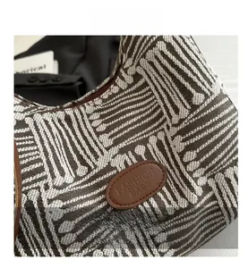 Detailed view of the woven plaid pattern and leather logo patch on the casual tote bag