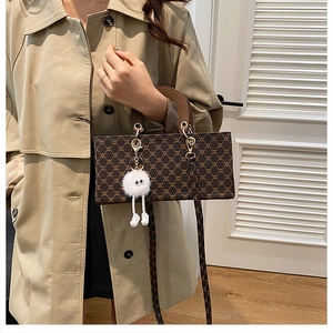 Detail view of stylish kids vintage crossbody bag with fur charm and chain strap