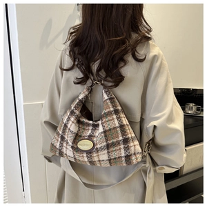 Shoulder view of large plaid tweed tote bag with leather trim and gold hardware