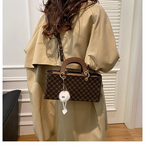 Détail d'un sac à main marron vintage pour filles avec breloque en peluche et sangle