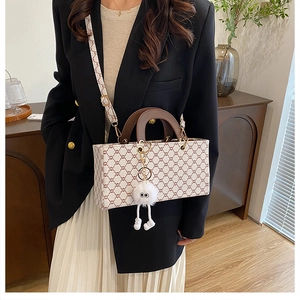 Detail of girls' cream grid crossbody bag with plush charm and stylish top handle