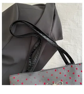 Detail of grey polka dot tote with red hearts and silver metal bow ornament