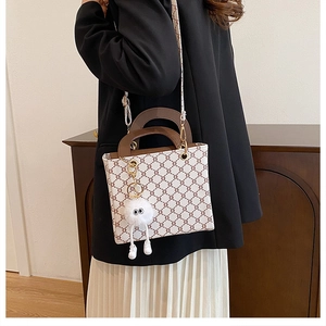 Detail of vintage square tote bag with geometric pattern and white plush eye charm