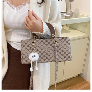 Detail of girls' jacquard handbag with brown leather handles and plush eye charm