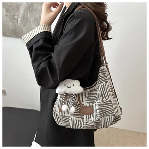 Plaid canvas shoulder bag with brown leather straps and white plush cloud pendant