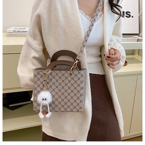 Close-up of vintage monogram tote bag with leather handles and cute plush charm detail