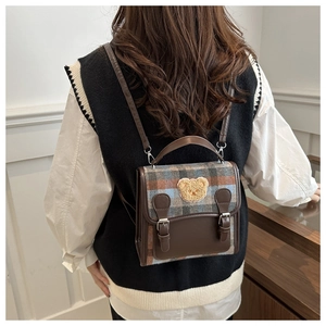 Detail of retro plaid tweed backpack with cute teddy bear embroidery and PU leather straps