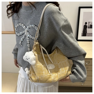 Detail of yellow knit shoulder bag with cloud charm and white leather strap