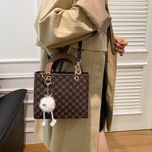 Fashionable retro tote bag with brown pattern, leather trim and cute white plush charm